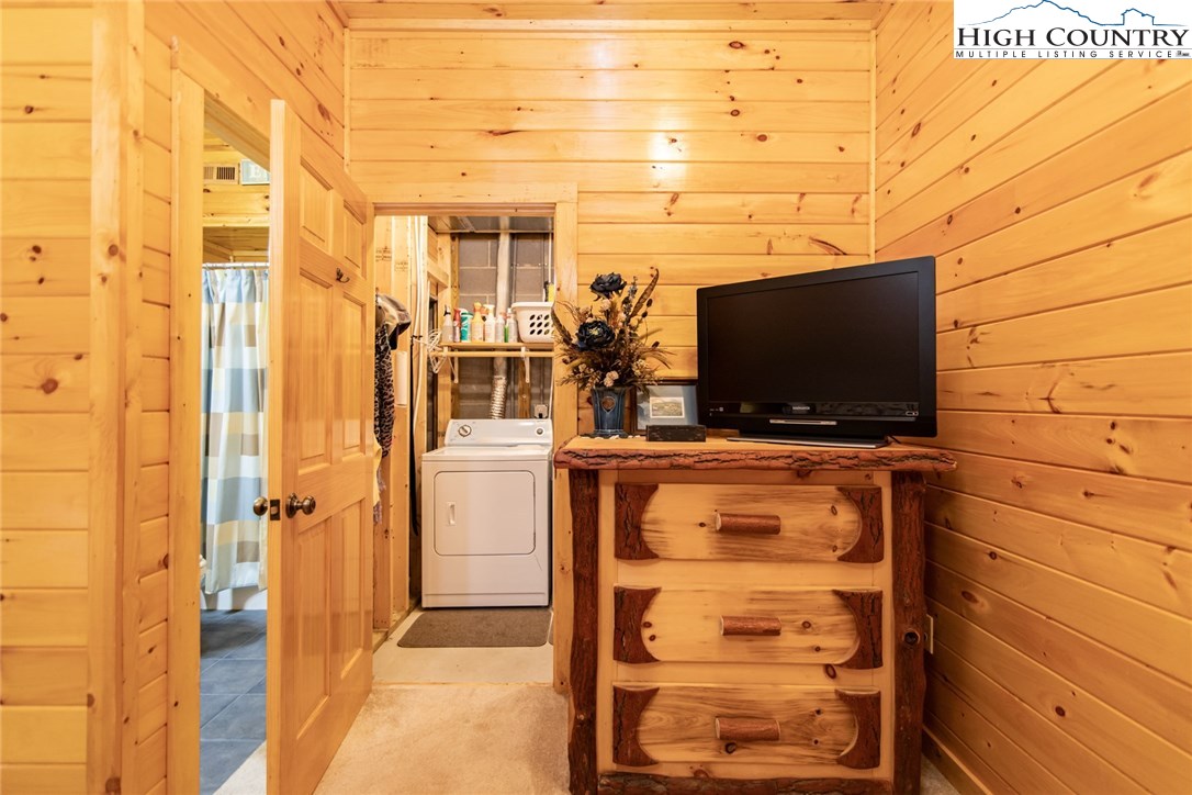 605 Wolf Pen Road Purlear, NC 28665 - Photo 32 of 50 a living room with a wooden floor and a flat screen tv