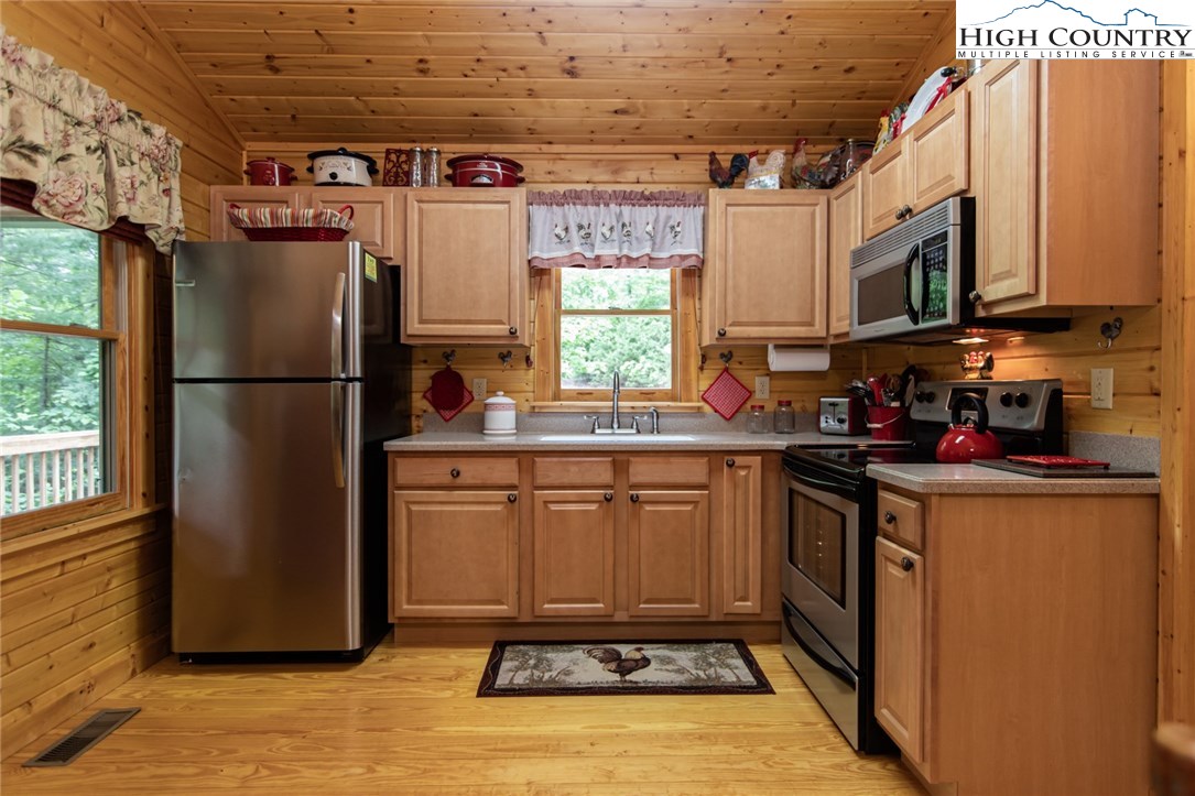 605 Wolf Pen Road Purlear, NC 28665 - Photo 8 of 50 a kitchen with stainless steel appliances granite countertop a refrigerator a sink a stove a microwave and cabinets