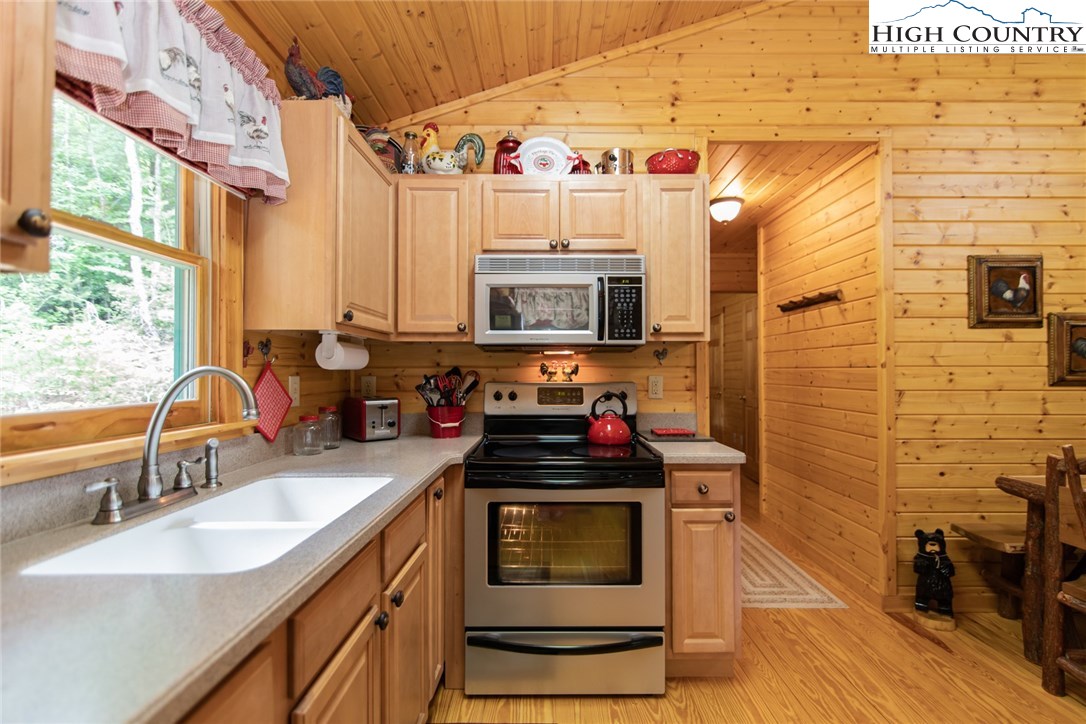 605 Wolf Pen Road Purlear, NC 28665 - Photo 9 of 50 a kitchen with stainless steel appliances a stove a sink and a microwave