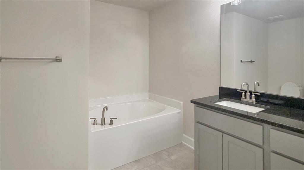 4086 Sagefield Drive Harmony, FL 34773 - Photo 13 of 16 a bathroom with a granite countertop sink and mirror