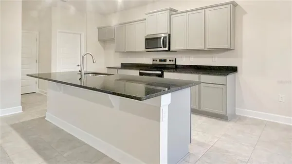 a kitchen with stainless steel appliances granite countertop a sink a microwave and cabinets