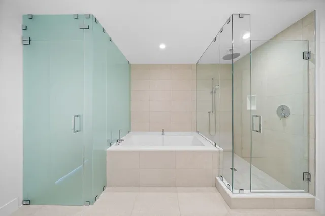 a large bathroom with a double vanity sink a large mirror and a bathtub