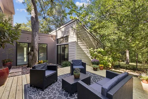 a view of a patio with couches table and chairs and potted plants