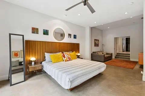 a bedroom with a large bed and a chandelier