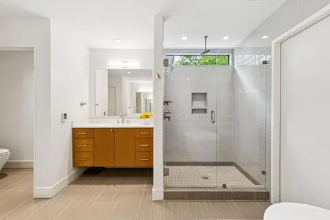 a bathroom with a mirror a sink and a shower