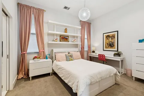 a bedroom with a bed couch and a window