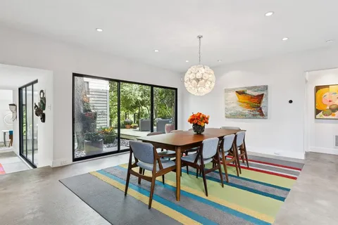 a view of a dining room with furniture a chandelier and wooden floor