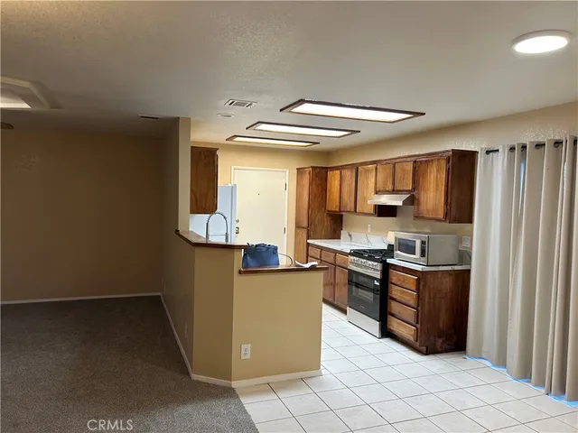 a kitchen with granite countertop a refrigerator and a stove top oven