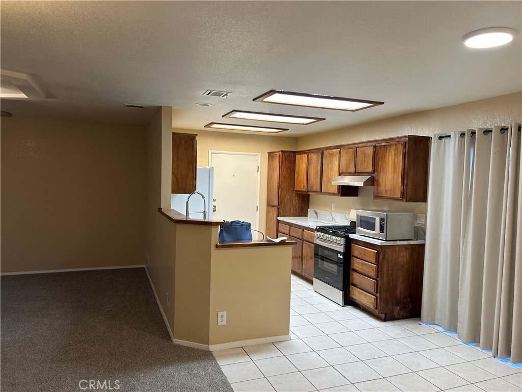 58481 Del Mar Street Yucca Valley, CA 92284 - Photo 7 of 29 a kitchen with granite countertop a refrigerator and a stove top oven