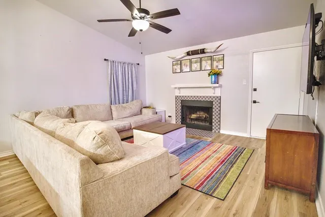 a living room with furniture fireplace and wooden floor