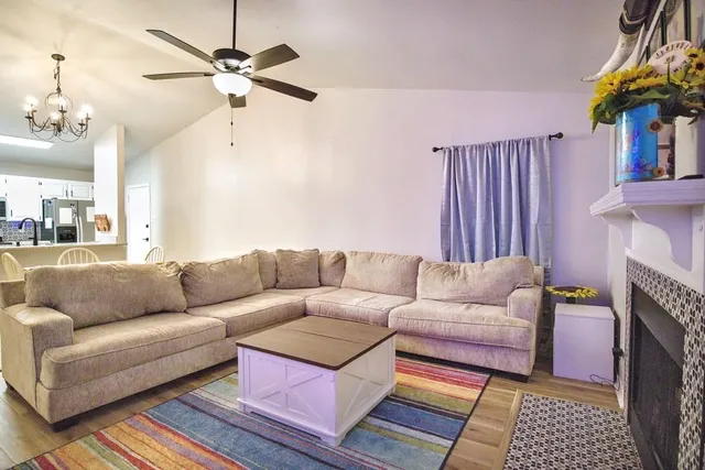 a living room with furniture a fireplace and a chandelier