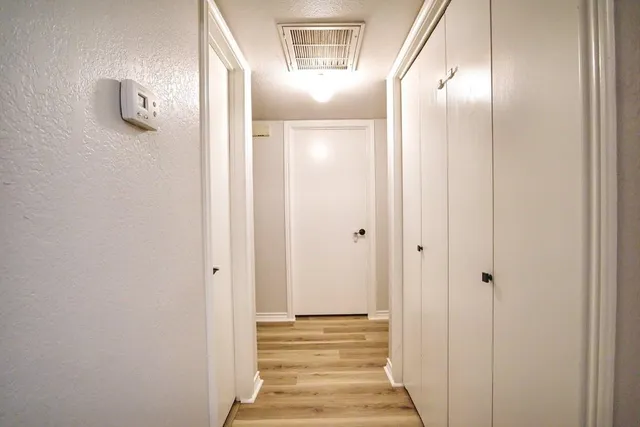 a view of a hallway with wooden floor and staircase