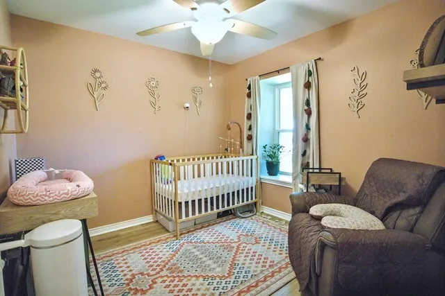 a living room with furniture and a baby crib