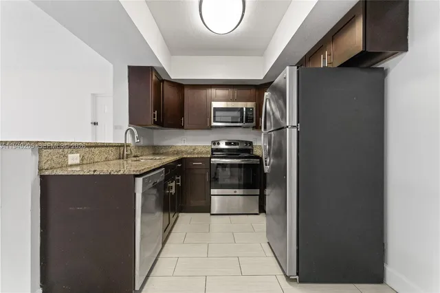 a kitchen with stainless steel appliances granite countertop a refrigerator and a stove