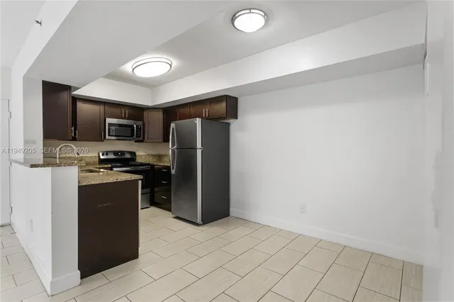 a kitchen with stainless steel appliances granite countertop a refrigerator and a stove top oven