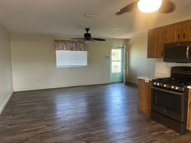 a kitchen with hard wood floors stainless steel appliances and wooden floor