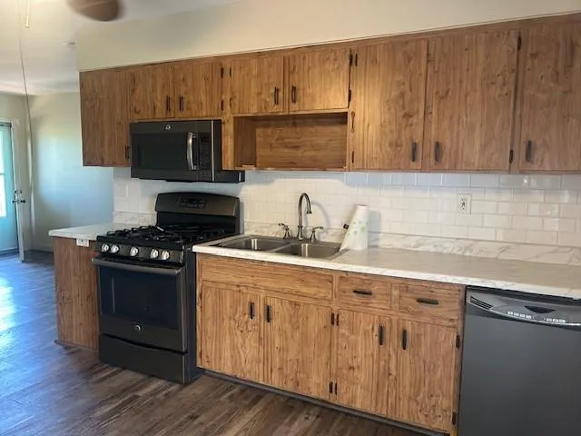a kitchen with granite countertop a sink cabinets and stainless steel appliances