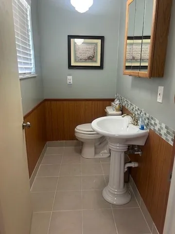 a bathroom with a sink a toilet and mirror