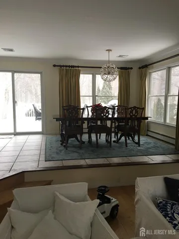 a dining hall with couches a coffee table and chairs with wooden floor