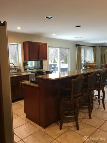 a kitchen with a dining table chairs and large window