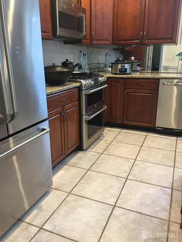 a kitchen with stainless steel appliances granite countertop a stove a sink and a refrigerator