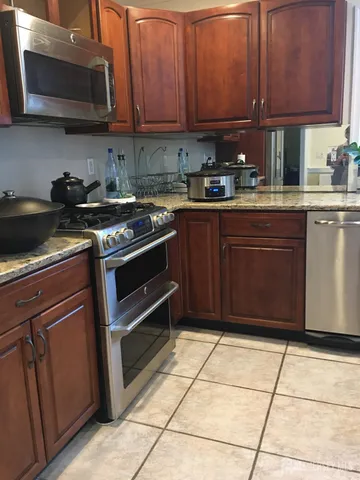 a kitchen with stainless steel appliances granite countertop a stove a sink and a microwave