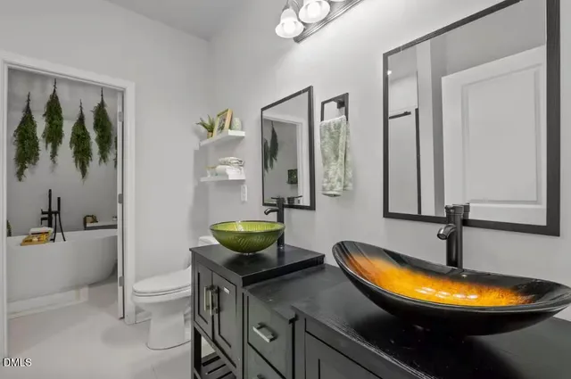 a bathroom with a granite countertop sink a toilet and mirror