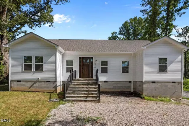 a view of a patio with couches potted plants and a big yard