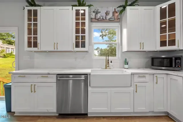 a kitchen with white cabinets and a window