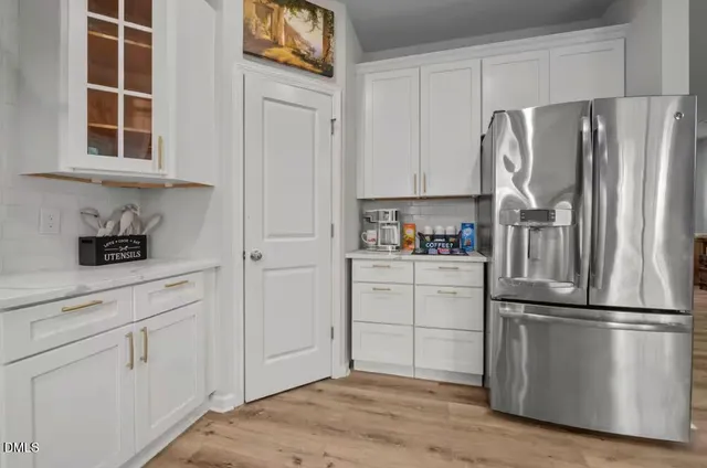 a kitchen with appliances a refrigerator and cabinets