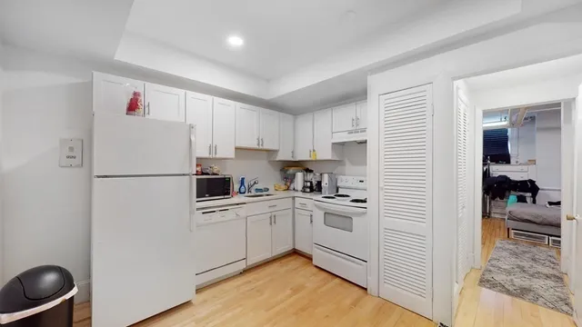 a kitchen with white cabinets and white appliances