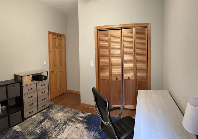 a view of a bedroom with furniture and wooden floor