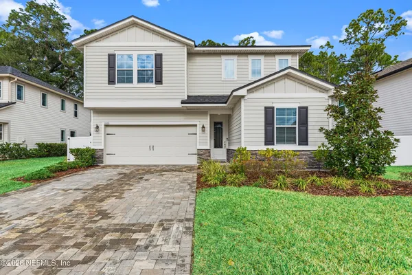 a front view of a house with a yard and garage