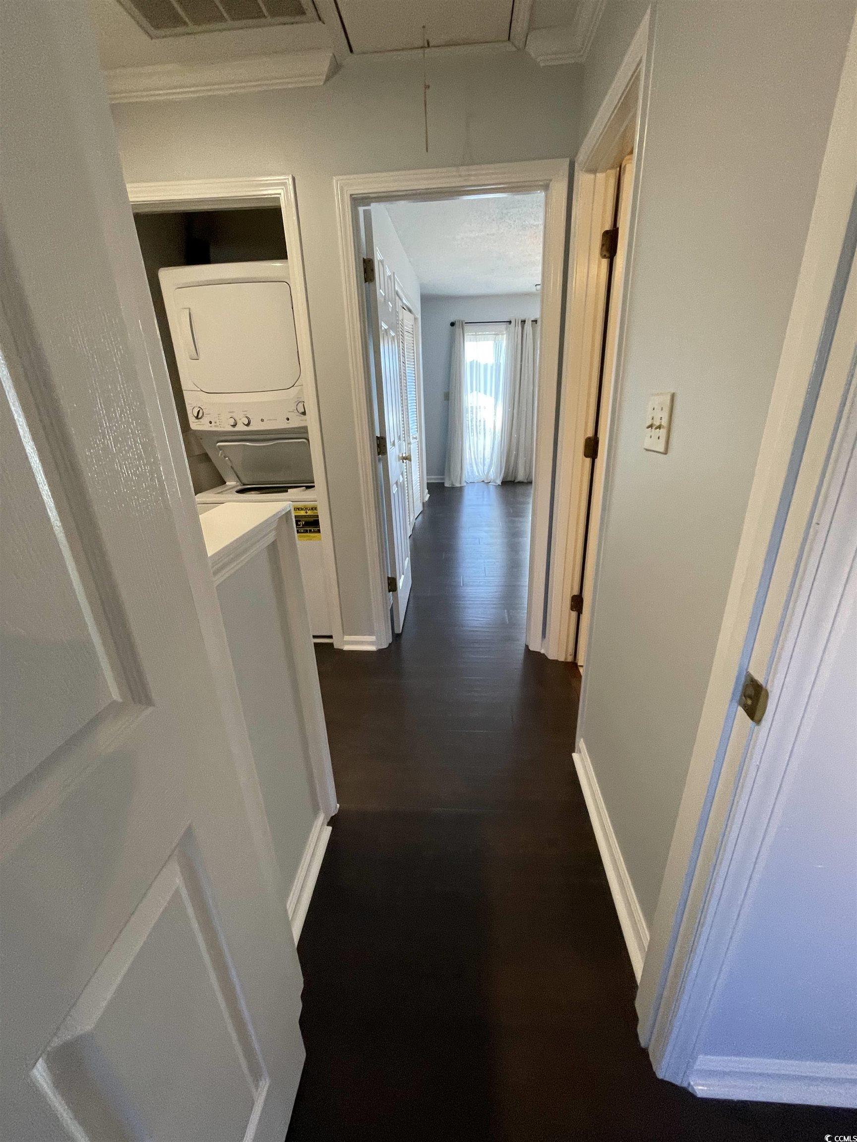 1851 Fairway Ridge Drive, Unit 7E Surfside Beach, SC 29575 - Photo 12 of 29 Hall featuring attic access, stacked washer / dryer, and dark wood-type flooring