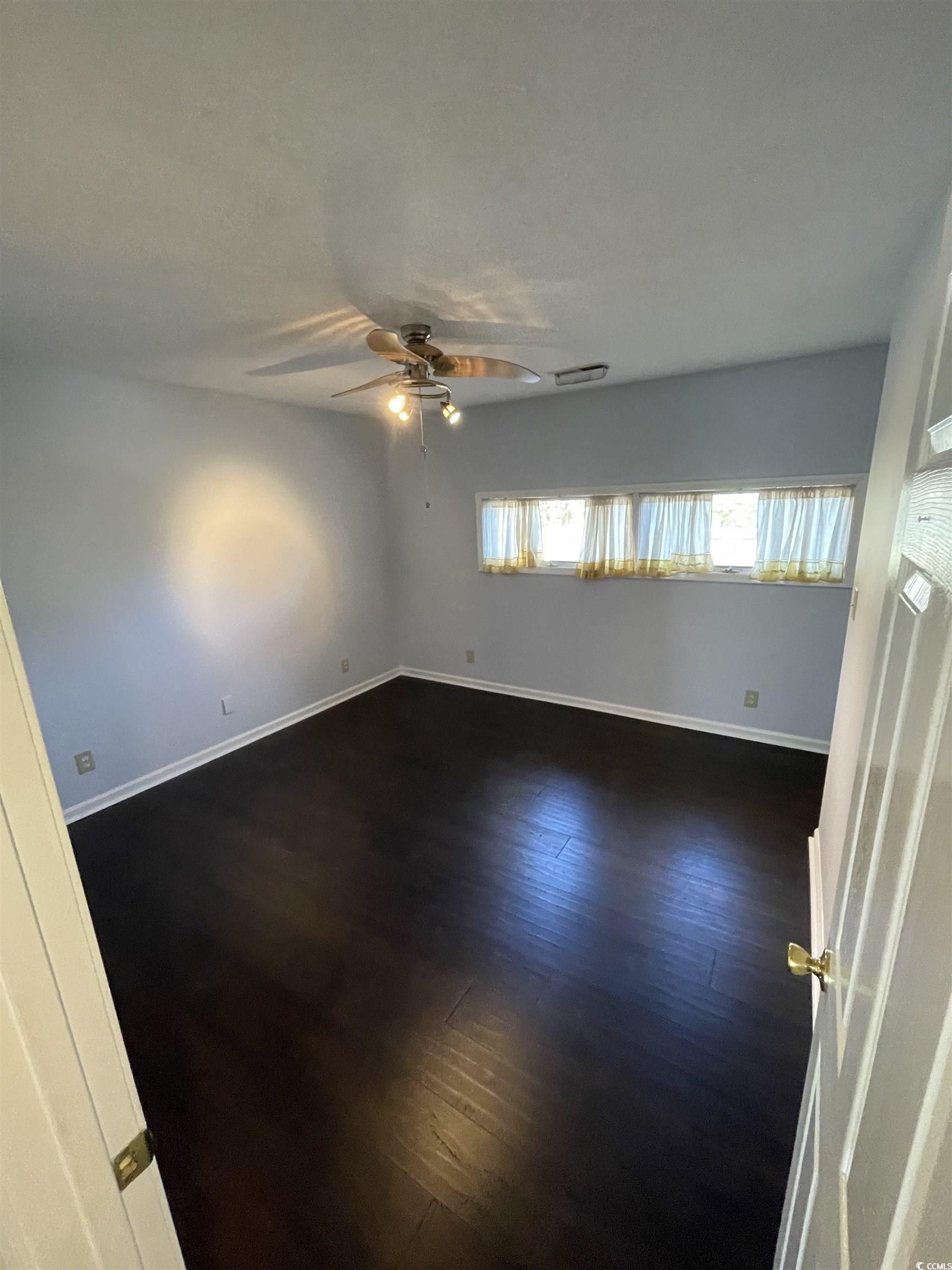 1851 Fairway Ridge Drive, Unit 7E Surfside Beach, SC 29575 - Photo 13 of 29 Spare room with dark wood-type flooring and ceiling fan