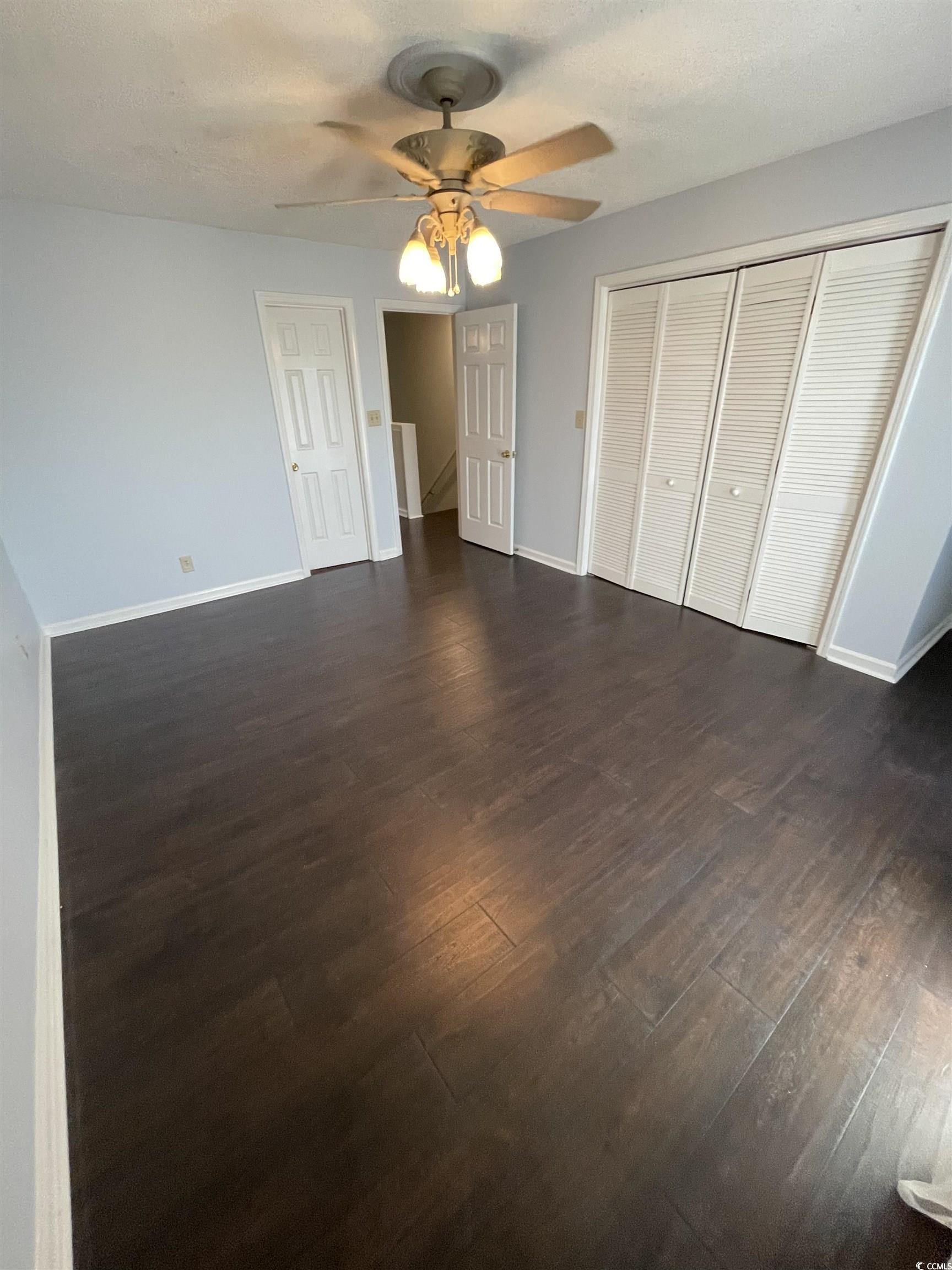 1851 Fairway Ridge Drive, Unit 7E Surfside Beach, SC 29575 - Photo 16 of 29 Unfurnished bedroom with dark wood-style floors, a closet, and a ceiling fan