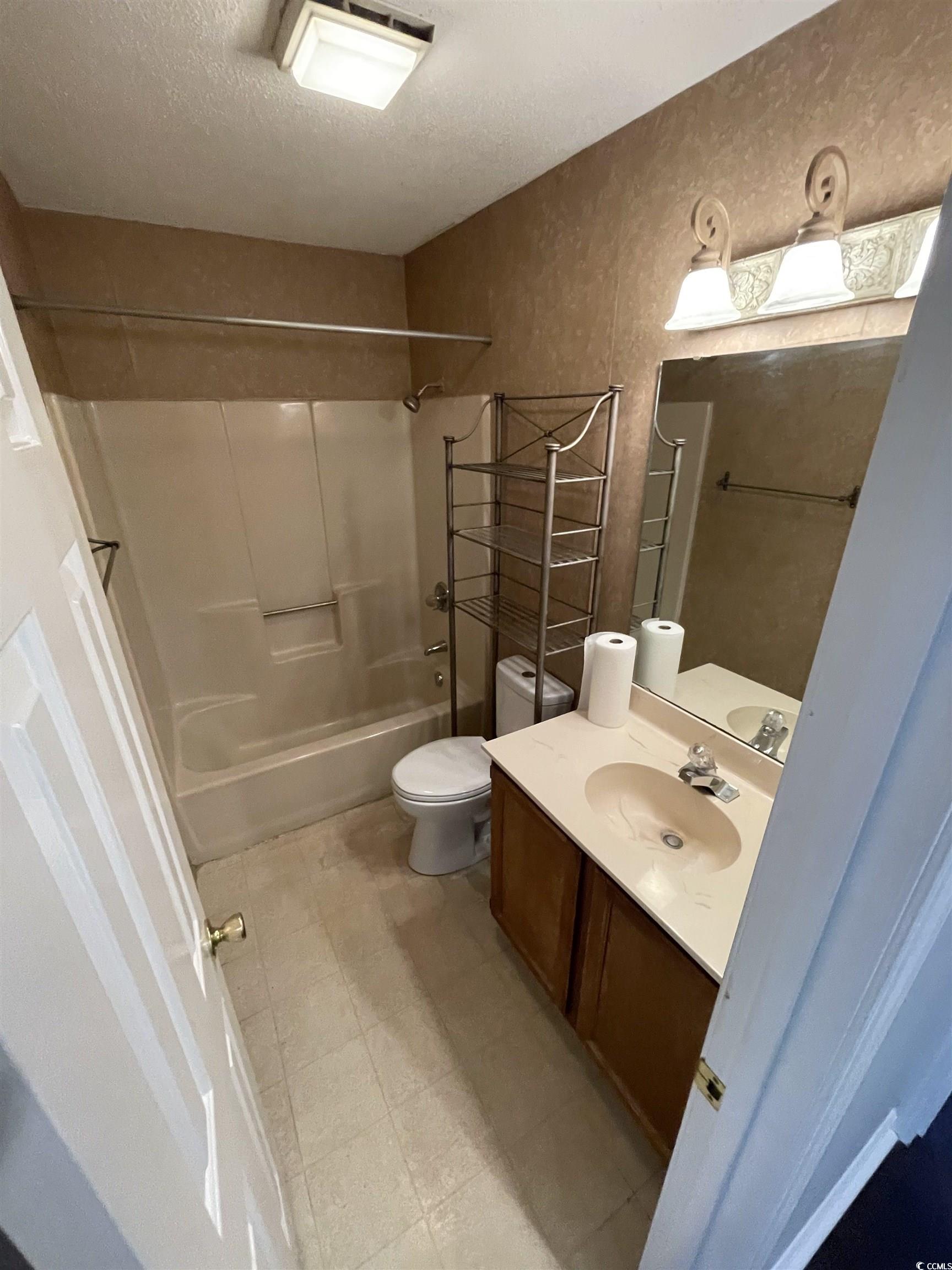 1851 Fairway Ridge Drive, Unit 7E Surfside Beach, SC 29575 - Photo 17 of 29 Bathroom featuring vanity, washtub / shower combination, light floors, and a textured ceiling