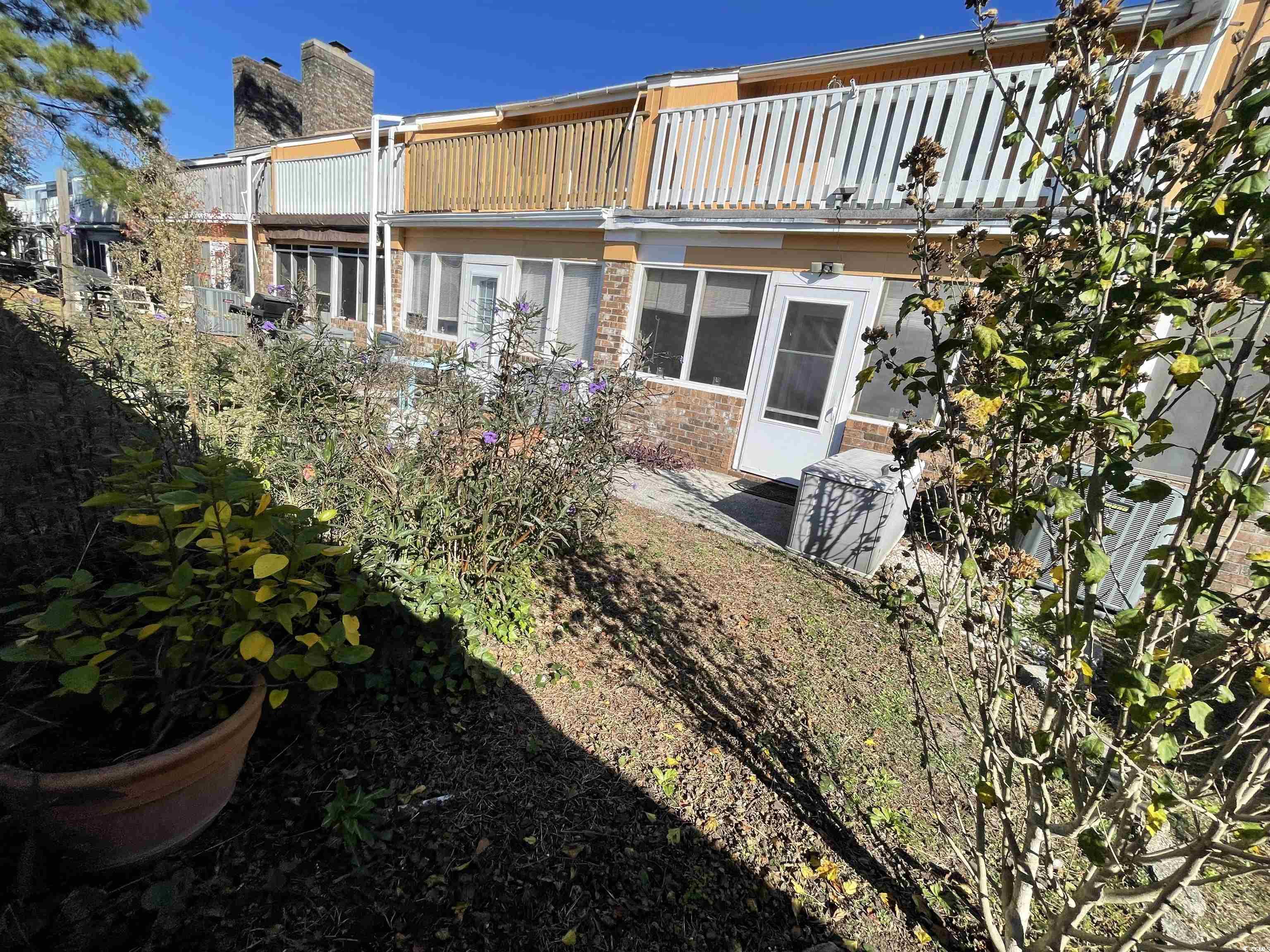 1851 Fairway Ridge Drive, Unit 7E Surfside Beach, SC 29575 - Photo 27 of 29 Rear view of house featuring a chimney and a balcony