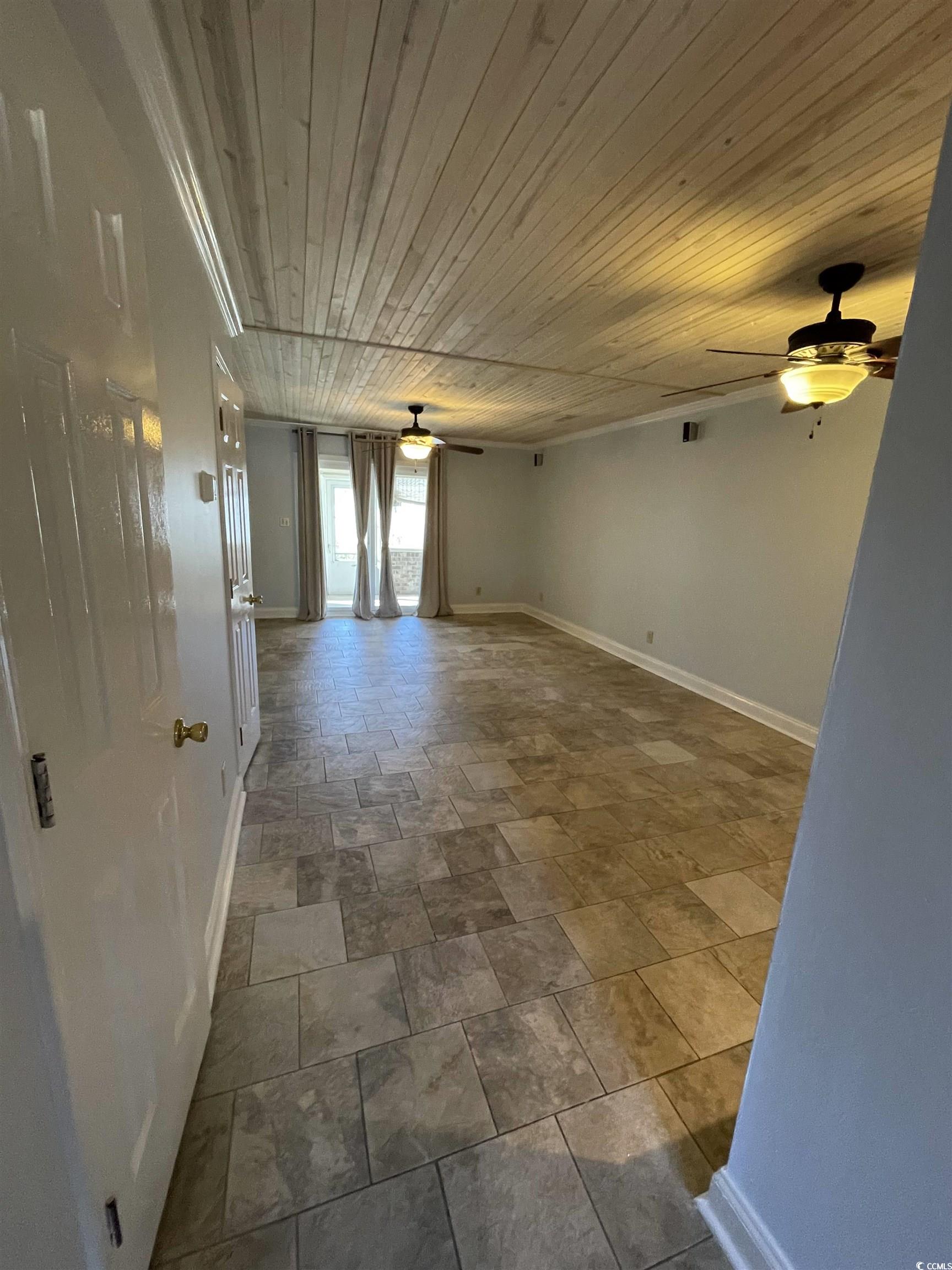 1851 Fairway Ridge Drive, Unit 7E Surfside Beach, SC 29575 - Photo 7 of 29 Empty room featuring a ceiling fan, wooden ceiling, and stone finish flooring