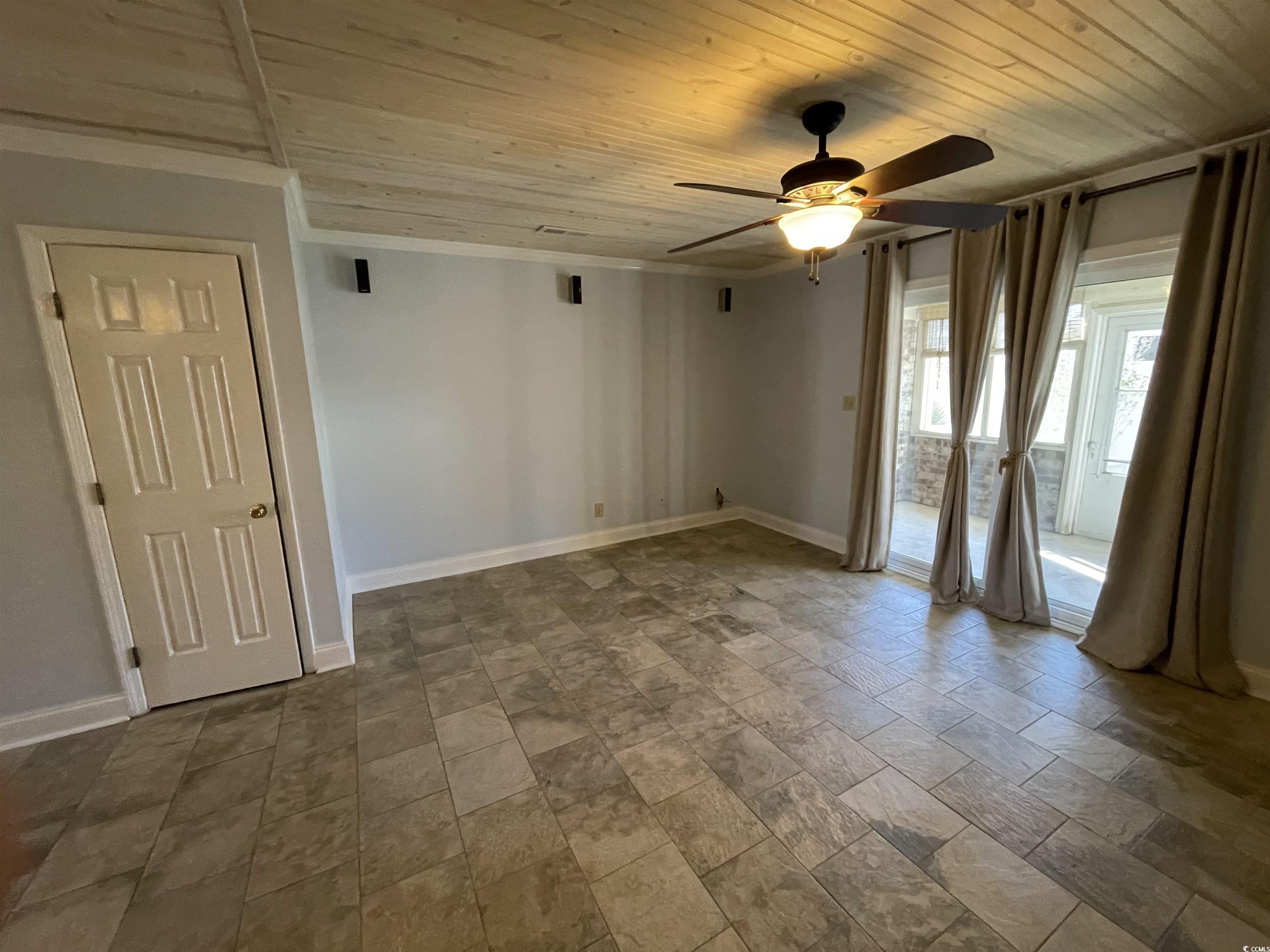 1851 Fairway Ridge Drive, Unit 7E Surfside Beach, SC 29575 - Photo 9 of 29 Spare room with wooden ceiling, ceiling fan, and stone finish flooring