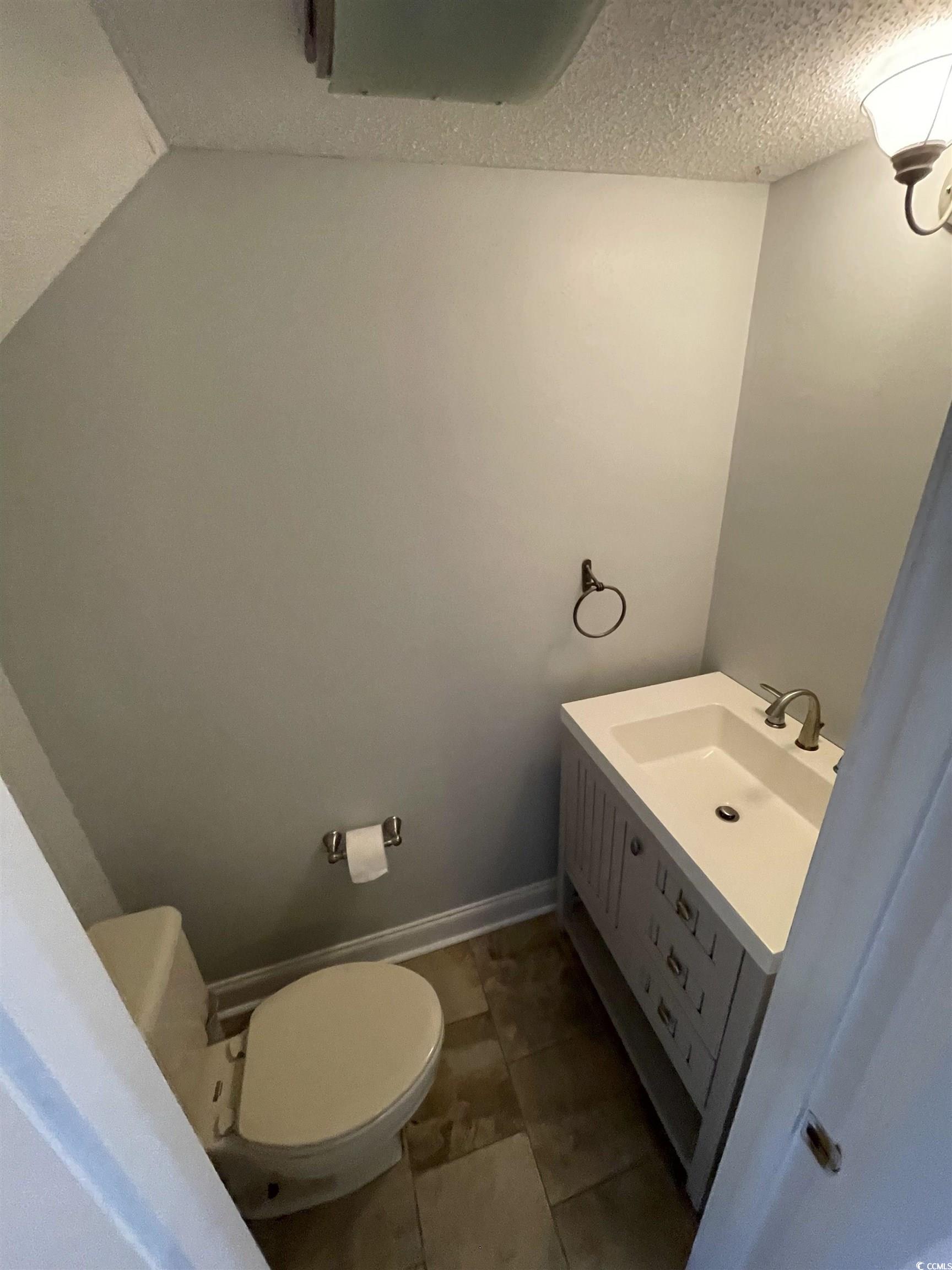 1851 Fairway Ridge Drive, Unit 7E Surfside Beach, SC 29575 - Photo 10 of 29 Half bathroom featuring vanity and a textured ceiling