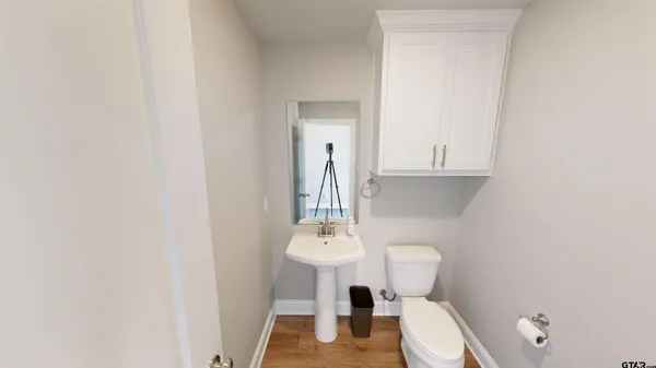 a bathroom with a toilet a sink and mirror