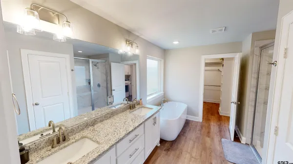 a spacious bathroom with a granite countertop tub sink and mirror