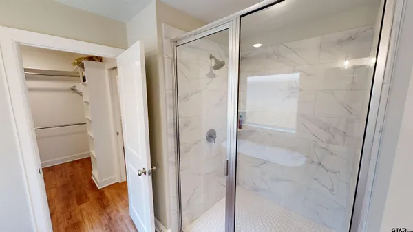 a bathroom with a glass shower door and a sink