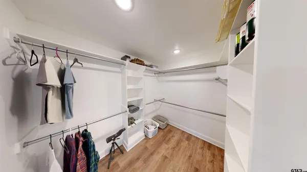 a view of walk in closet with clothes and shoes