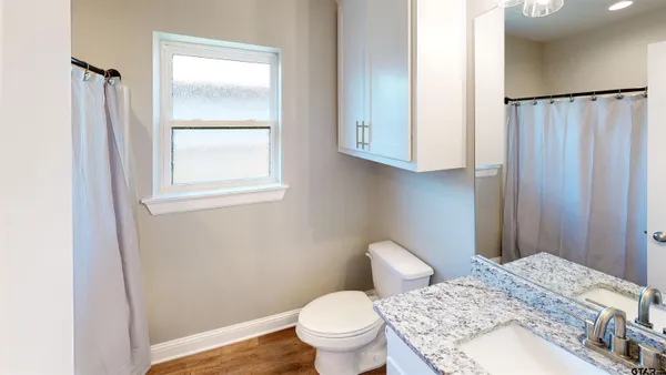 a bathroom with a granite countertop sink toilet and shower