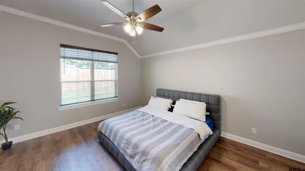 a bedroom with a large bed and a chandelier
