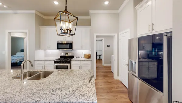 a kitchen with granite countertop a refrigerator stove and sink