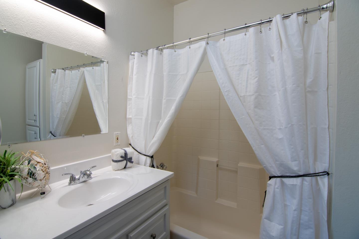 535 Sobrato Drive Campbell, CA 95008 - Photo 26 of 32 a bathroom with a sink a mirror and a shower curtain