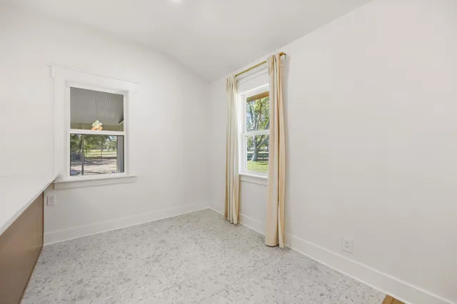 an empty room with windows and closet